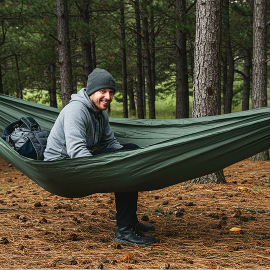Camping hammock in the forest with a smiling man
