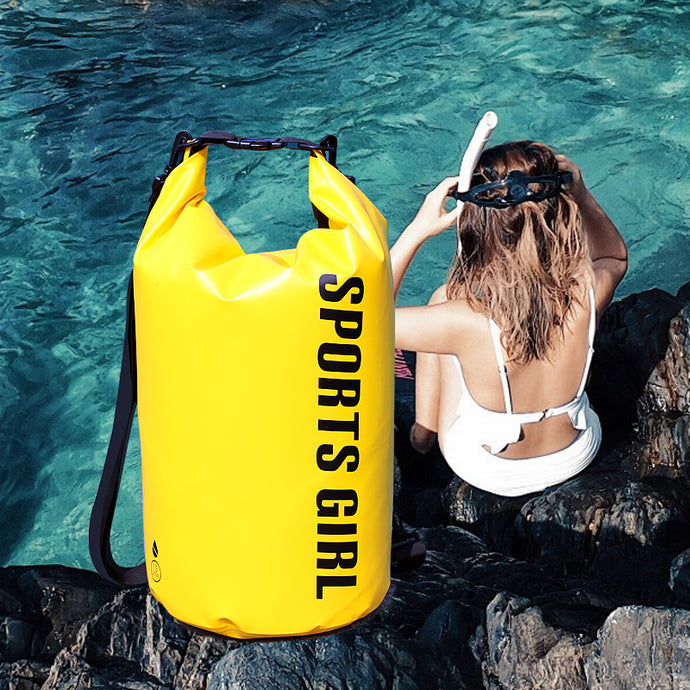 Woman sitting by a pool with a yellow 'SPORTS GIRL' bag next to her.