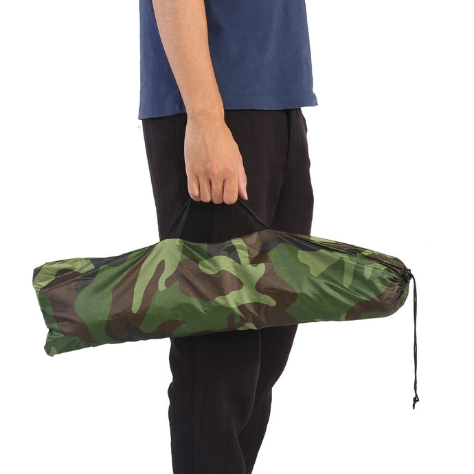 Person holding a camouflage-patterned bag on a white background