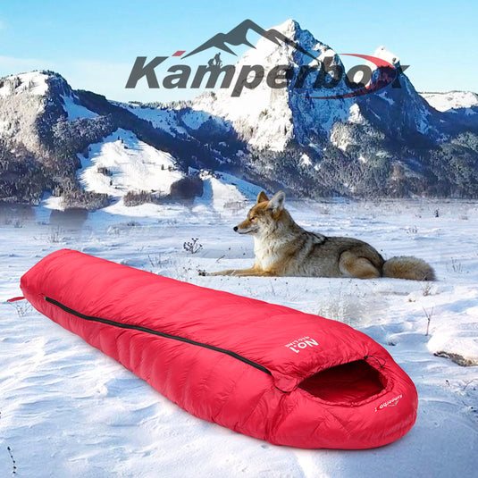 Red sleeping bag on snow with a wolf and mountainous landscape, featuring the Kamperbox brand.