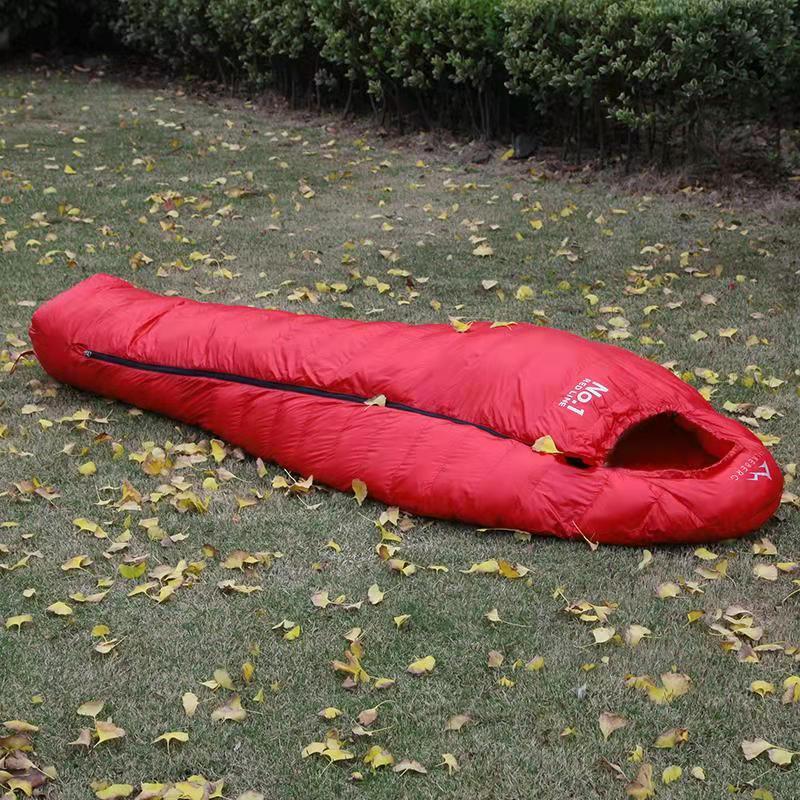 Load image into Gallery viewer, Red sleeping bag on grass with fallen leaves
