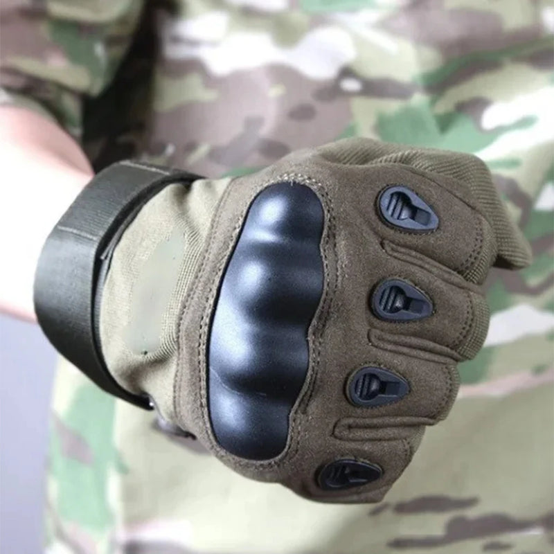 Load image into Gallery viewer, Brown tactical glove with black padding on a camouflage background
